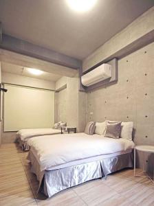 a bedroom with two beds and a air conditioner at Mei Jen house B&B 日月潭民宿 in Yuchi