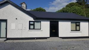 a white house with a black door at Ashford Villa -Cottage 2 in Cong