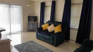 a living room with a black chair with yellow pillows at Ashford Villa -Cottage 2 in Cong
