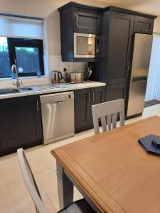 a kitchen with black cabinets and a table with chairs at Ashford Villa -Cottage 2 in Cong