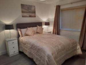 a bedroom with a bed and a night stand with two lamps at Ashford Villa -Cottage 2 in Cong