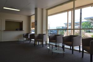 poczekalnia z krzesłami, stołami i oknami w obiekcie The Australian Hotel Motel w mieście Dalby