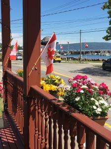 a balcony with flowers and a canadian flag at Harmony B&B and Suites in Digby