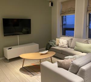 un soggiorno con divano e tavolo di City Center Apartment ad Ålesund