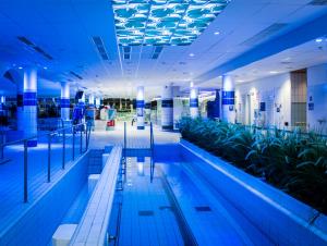 a swimming pool in a building with blue lighting at Spa Hotel Kunnonpaikka in Kuopio