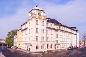 un grand bâtiment avec une tour d'horloge en haut dans l'établissement Hotel Alekto, à Freiberg