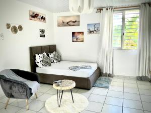a living room with a couch and a table at LE ROSA PARKS CLÉMARTHA in Kourou