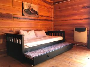 a bedroom with a bed in a log cabin at Cabañas San Urbano 1 in Villa Yacanto +38 photos