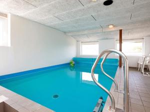 a swimming pool in a house with blue water at 10 person holiday home in Ringk bing in Klegod