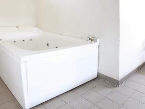 a white bath tub sitting in a bathroom at 10 person holiday home in Ringk bing in Klegod