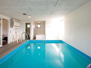 a swimming pool in a living room with a blue at 10 person holiday home in Ringk bing in Klegod