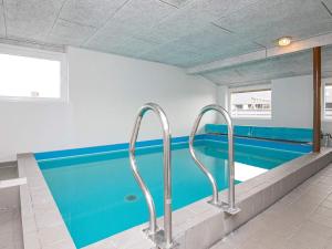 a swimming pool with two metal hand rails in a building at 10 person holiday home in Ringk bing in Klegod