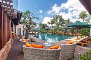 una terrazza all'aperto con sedie e una piscina in un resort di Alam Wayang Ubud - CHSE Certified ad Ubud