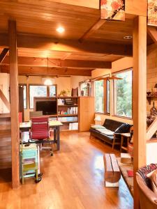 ein Wohnzimmer mit einem Sofa, einem Tisch und Stühlen in der Unterkunft ガーデンハウス Mako Land in Toyama