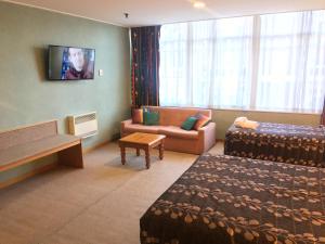 um quarto de hotel com duas camas e um sofá em Leviathan Hotel em Dunedin