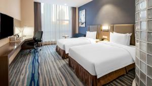 um quarto de hotel com duas camas e uma televisão de ecrã plano em Holiday Inn Express Shenyang North Station, an IHG Hotel em Shenyang