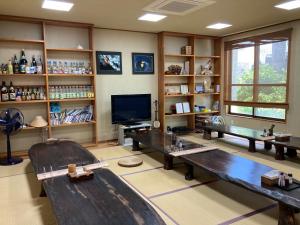 Habitación con 2 mesas, TV y estanterías en Joya en Isla Ishigaki