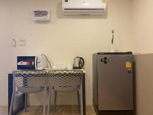 eine Küche mit einem Tisch und einem Kühlschrank in der Unterkunft Bansuay Phra Nang Klao in Nonthaburi