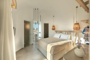 Un dormitorio blanco con una cama y una mesa. en Alafropetra Luxury Suites, en Akrotiri 64 fotos más