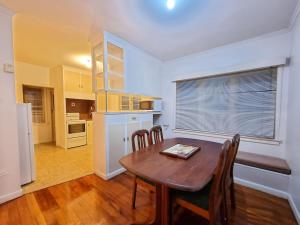 cocina y comedor con mesa y sillas en Cozy 3BR Mt Roskill - Heat Pump & Wifi & Netflix en Auckland