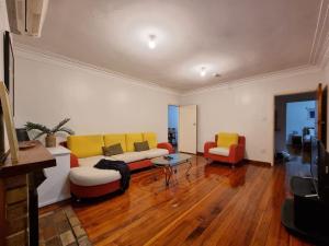 uma sala de estar com um sofá e duas cadeiras em Cozy 3BR Mt Roskill - Heat Pump & Wifi & Netflix em Auckland