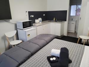 een woonkamer met een bank en een keuken bij Jabiru Motel in Nambucca Heads