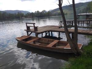 un barco de madera sentado en el agua junto a un muelle en Kuća-Zvorničko jezero, en Mali Zvornik