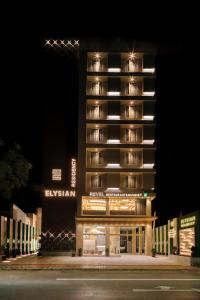 un grand bâtiment avec une façade éclairée la nuit dans l'établissement Hotel Elysian Residency, à Ahmedabad