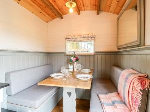 a dining room with a table and two benches at The Lazy Mare by The Water in Rugeley