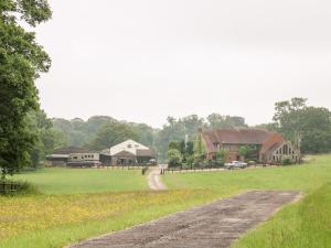 a dirt road leading to a barn and a farm at The Lazy Mare by The Water in Rugeley