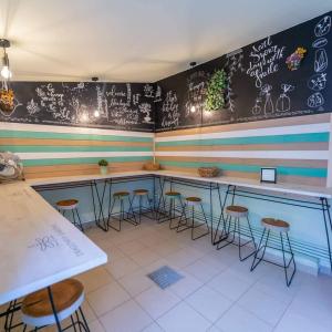 a bar with stools and a wall with drawings on it at Dragonfly Gardens - The Wagons in Braşov