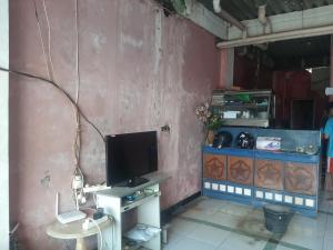 a living room with a tv and a table with a table at SPOT ON 90535 Cimanuk Pavilion in Bengkulu