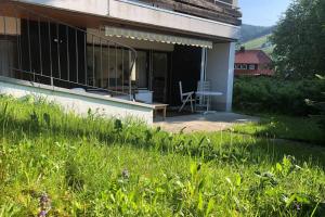 um alpendre de uma casa com uma mesa e uma cadeira em Gemütliche Fewo mit Sonnenterrasse em Bernau im Schwarzwald