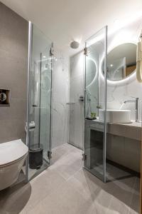 a bathroom with a glass shower and a toilet at Parnon Hotel in Athens