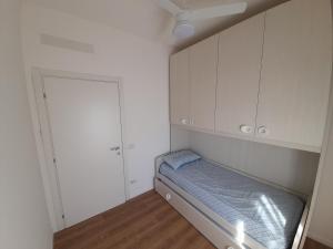 um pequeno quarto com uma cama e armários brancos em Casa Stella Marina em Bellaria-Igea Marina