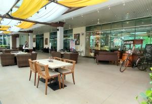 a restaurant with a table and chairs and a person at Woodland Park Residence-Relaxed and Friendly in Jakarta