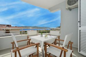 a table and chairs on a balcony with a view of the ocean at Apartments Vrania in Seget Vranjica