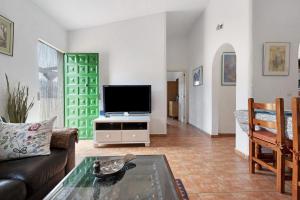 Finca Edén في غيا ذي إسورا: غرفة معيشة مع أريكة وتلفزيون بشاشة مسطحة