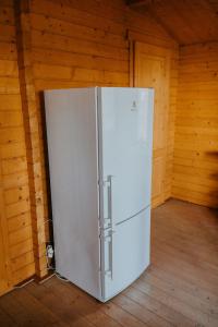 a refrigerator in a room with wooden walls at Atpūtas kempings Usma in Usma