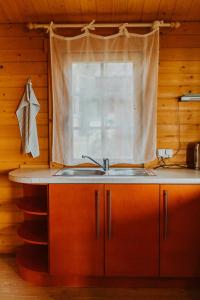a kitchen with a sink and a window at Atpūtas kempings Usma in Usma +27 photos