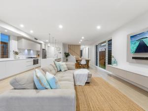 a living room with a couch and a kitchen at Nautilus Ocean Breeze in Kingscliff