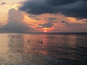a group of people in the water at sunset at Jasmine & Tea House in Mae Nam