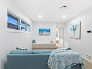 a living room with a blue couch and windows at Nautilus Ocean Breeze in Kingscliff
