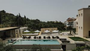 a swimming pool with lounge chairs and a building at Casa Costa Suites in Kanali