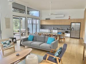 a living room with a couch and a kitchen at Beachfront Eclipse with Pool in Casuarina