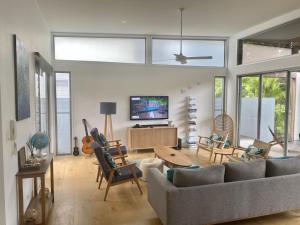 a living room with a couch and a table at Beachfront Eclipse with Pool in Casuarina