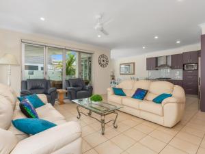 ein Wohnzimmer mit zwei weißen Sofas und einem Tisch in der Unterkunft Casuarina Dreaming Townhouse with Pool in Kingscliff