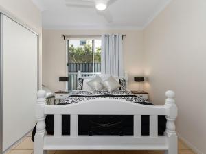 ein weißes Bett in einem Zimmer mit Fenster in der Unterkunft Casuarina Dreaming Townhouse with Pool in Kingscliff + 15 Fotos