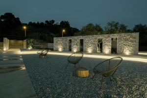 three chairs sitting in front of a stone building at Casa Costa Suites in Kanali