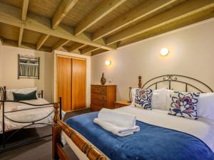 1 dormitorio con 2 camas y techo de madera en Banjo Apartments, en Thredbo